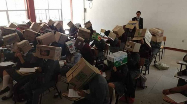 Para evitar que copien, profesor de pone cajas de cartón en la cabeza de sus alumnos