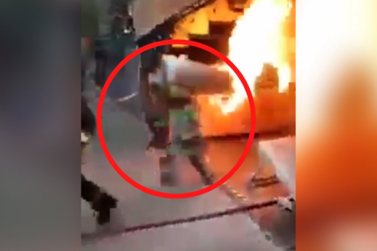 ¡Héroe! Bombero carga tanque de gas en llamas